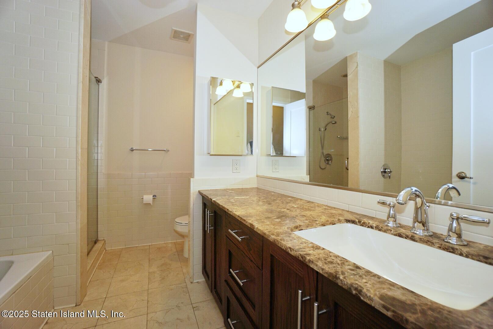 90 Bay Street Landing, Unit 4B Staten Island, NY 10301 - Photo 9 of 42 a bathroom with a granite countertop sink a mirror and a shower