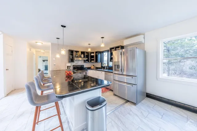 a kitchen with stainless steel appliances granite countertop a refrigerator and a stove top oven
