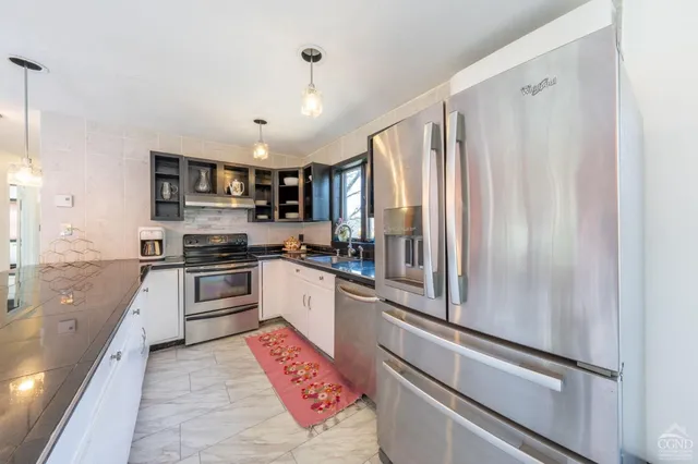a kitchen with stainless steel appliances granite countertop a refrigerator and a sink
