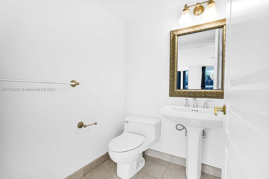 8925 Collins Avenue, Unit 2E Surfside, FL 33154 - Photo 14 of 46 a bathroom with a toilet sink and mirror