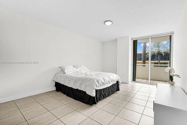 a spacious bedroom with a bed and glass door