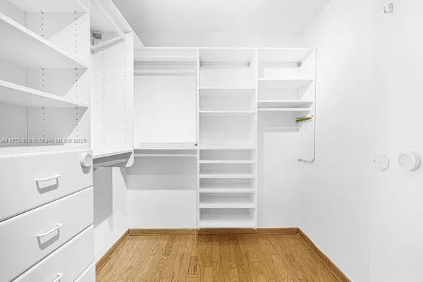 a large white kitchen with stainless steel appliances granite countertop a sink stove and cabinets