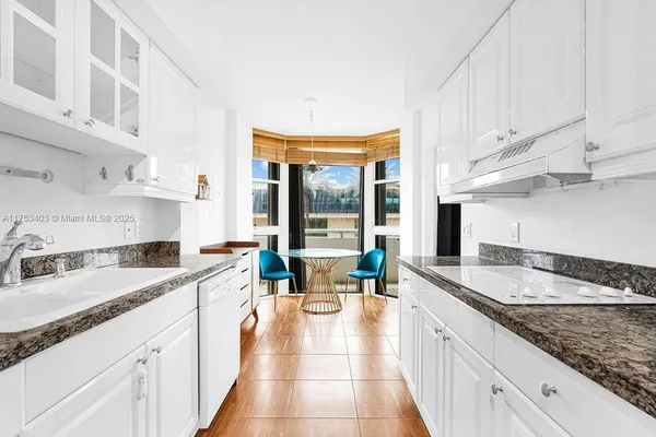 a kitchen with granite countertop a sink and a cabinets