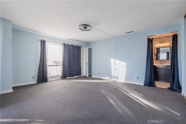 a view of an empty room with closet and wooden floor