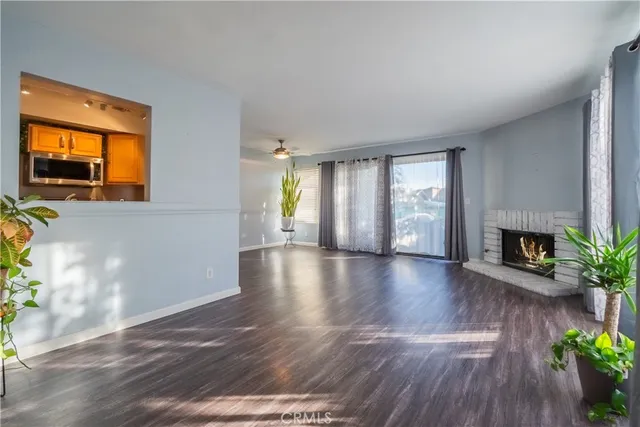 a view of an empty room with a fireplace and a window