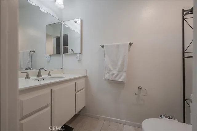 a bathroom with a granite countertop sink toilet and mirror