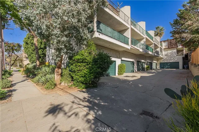 a view of a street with plants and trees