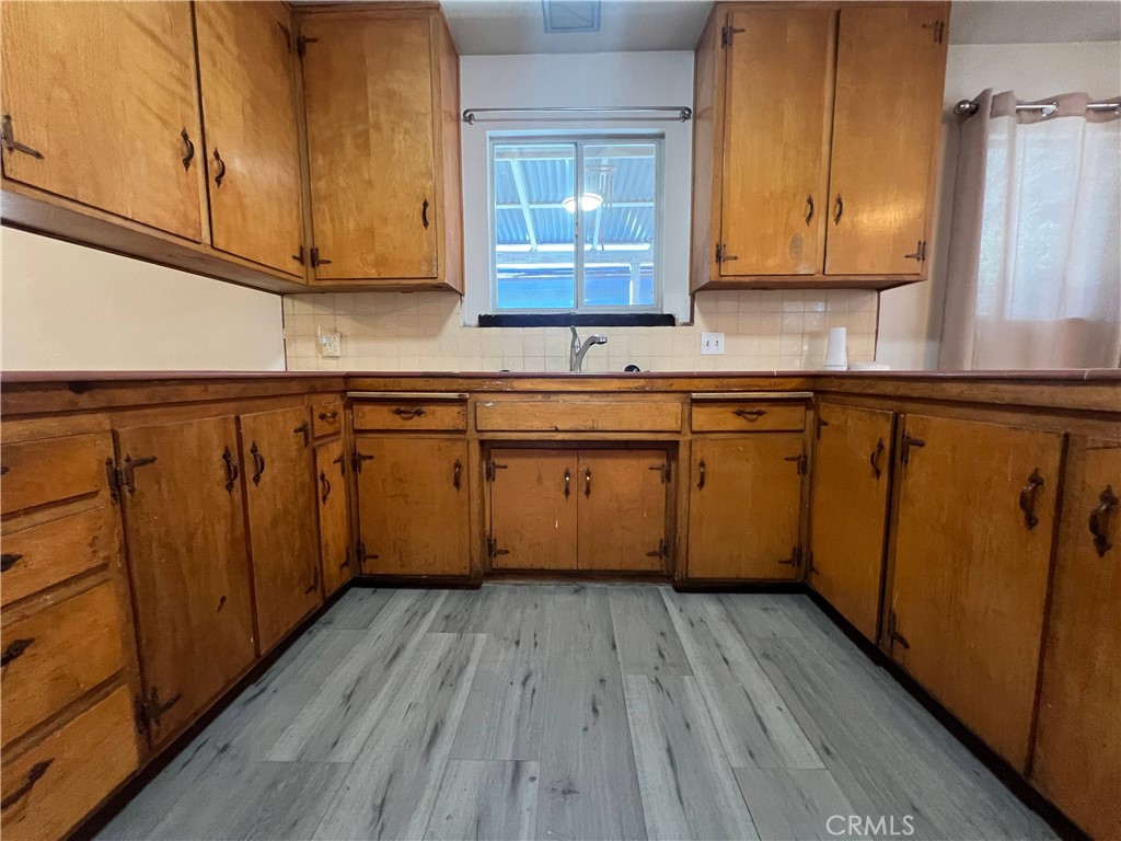 15558 Del Rey Drive Victorville, CA 92395 - Photo 10 of 32 a kitchen with wooden floors stainless steel appliances a sink and a window