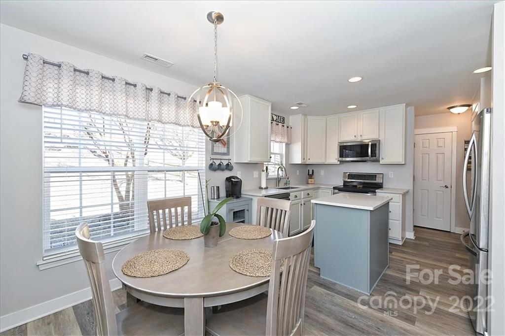 7671 Black Hawk Lane Tega Cay, SC 29708 - Photo 11 of 45 a open dining room with kitchen island stainless steel appliances furniture a chandelier and a view of kitchen