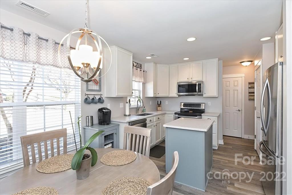 7671 Black Hawk Lane Tega Cay, SC 29708 - Photo 12 of 45 a kitchen with stainless steel appliances granite countertop a sink a stove a refrigerator cabinets and living room view