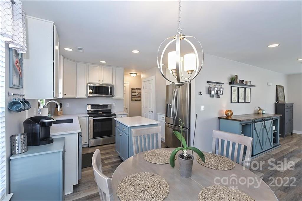 7671 Black Hawk Lane Tega Cay, SC 29708 - Photo 14 of 45 a kitchen with sink refrigerator dining table and chairs