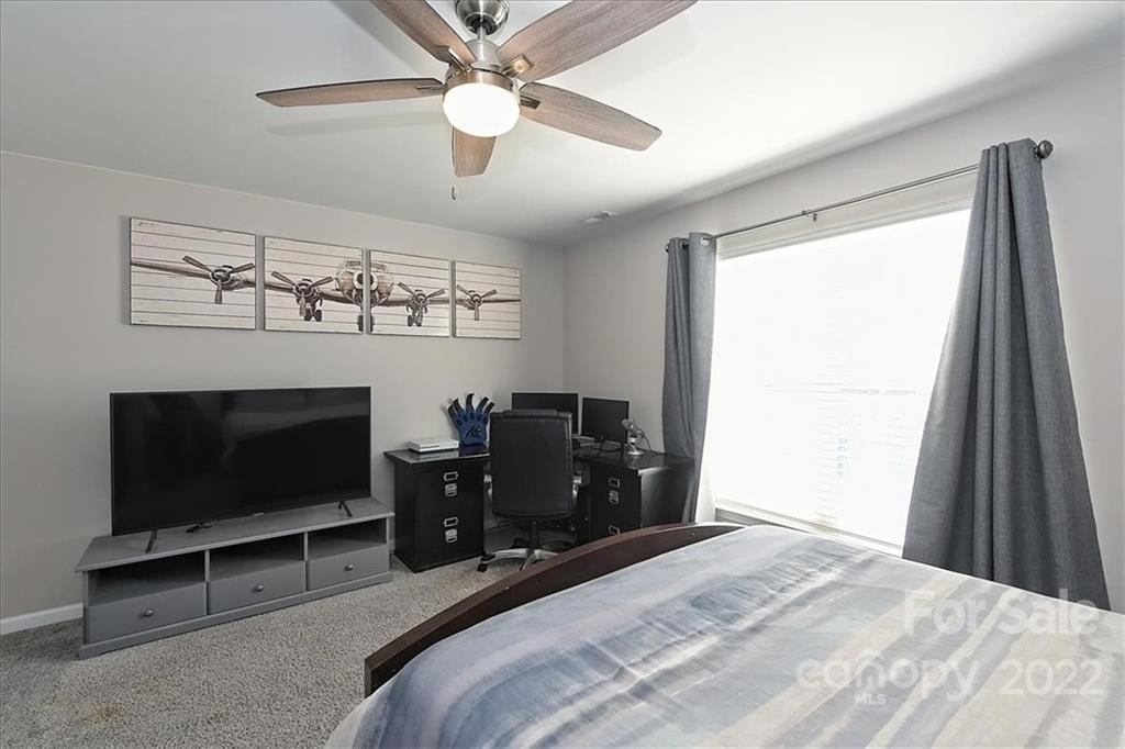 7671 Black Hawk Lane Tega Cay, SC 29708 - Photo 30 of 45 a bedroom with a bed and a flat tv screen on the dresser