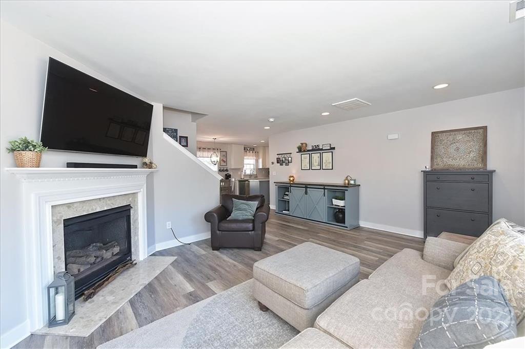 7671 Black Hawk Lane Tega Cay, SC 29708 - Photo 7 of 45 a living room with furniture a flat screen tv and a fireplace