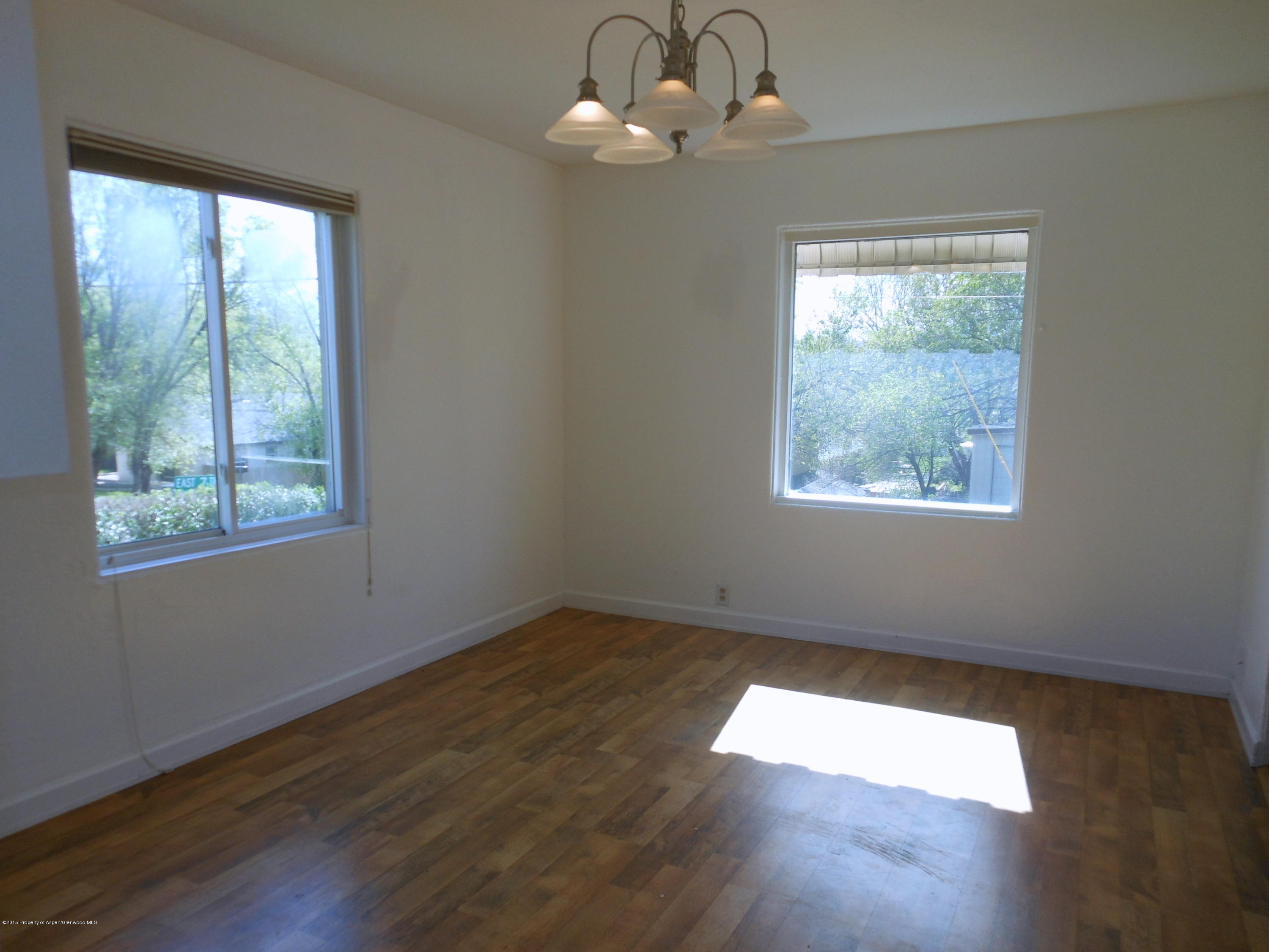 300 East 7th Street Rifle, CO 81650 - Photo 12 of 24 a view of an empty room with wooden floor and a window