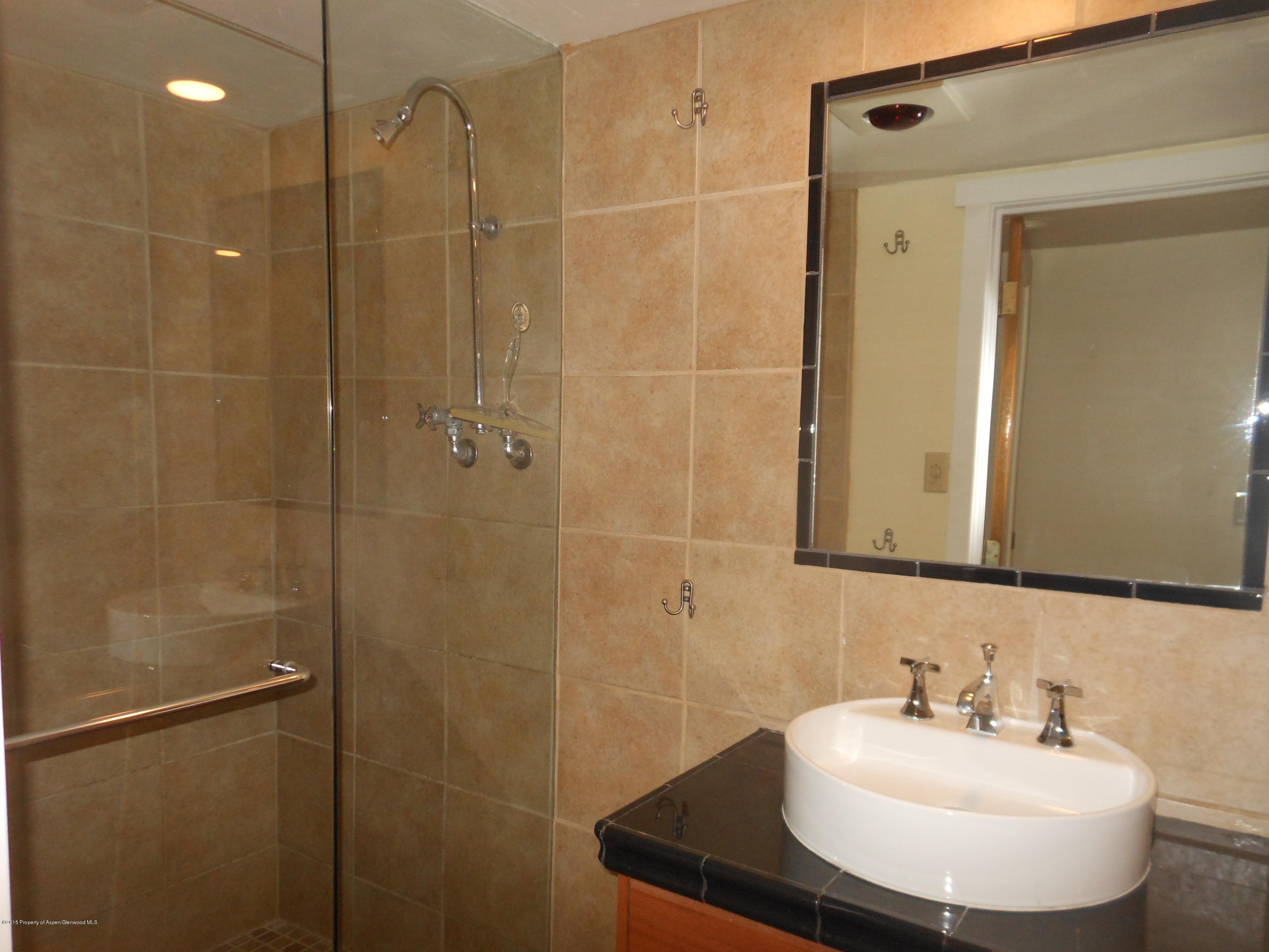 300 East 7th Street Rifle, CO 81650 - Photo 16 of 24 a bathroom with a sink shower and a mirror