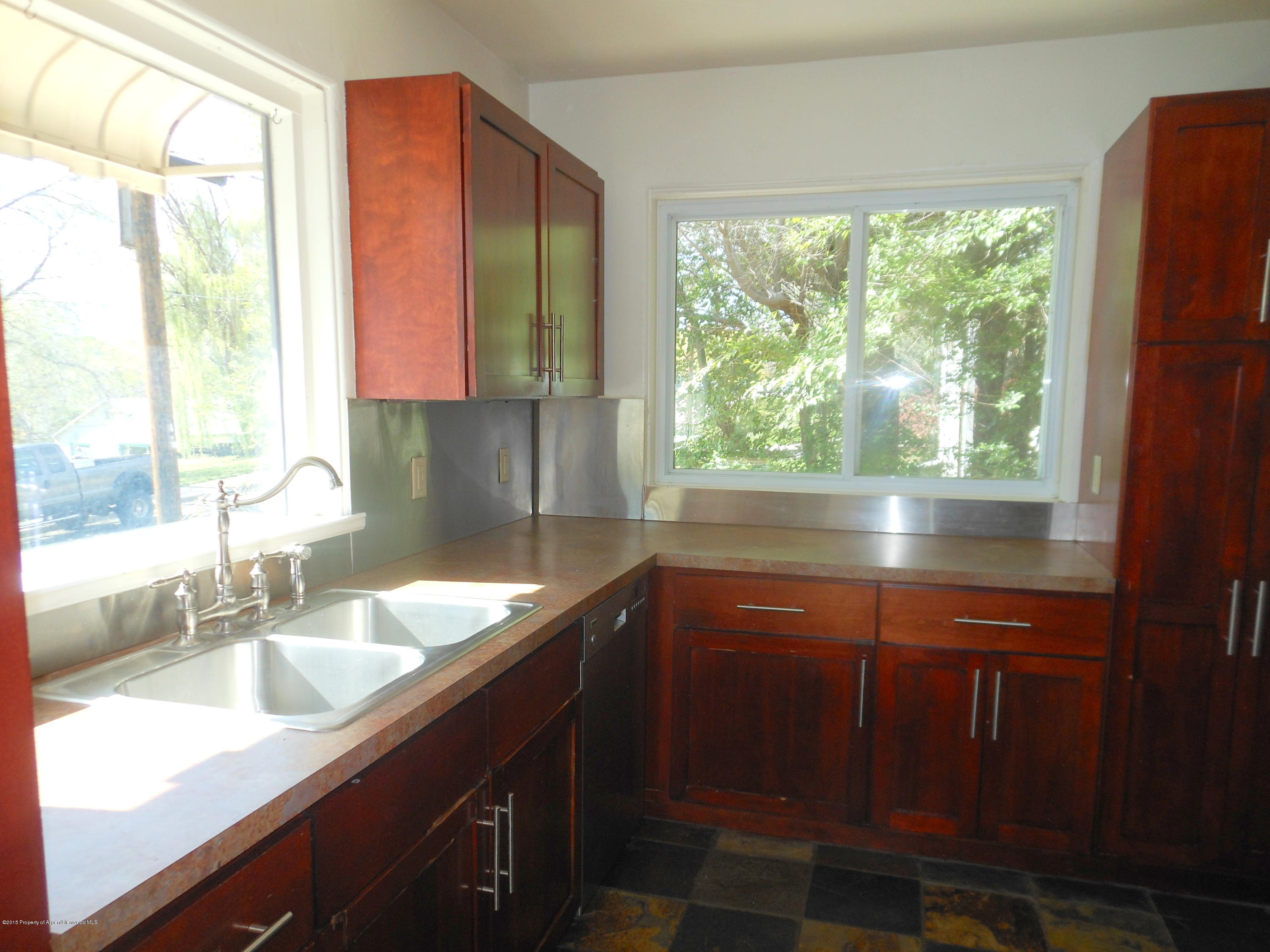 300 East 7th Street Rifle, CO 81650 - Photo 6 of 24 a kitchen with a sink a counter top and a large window