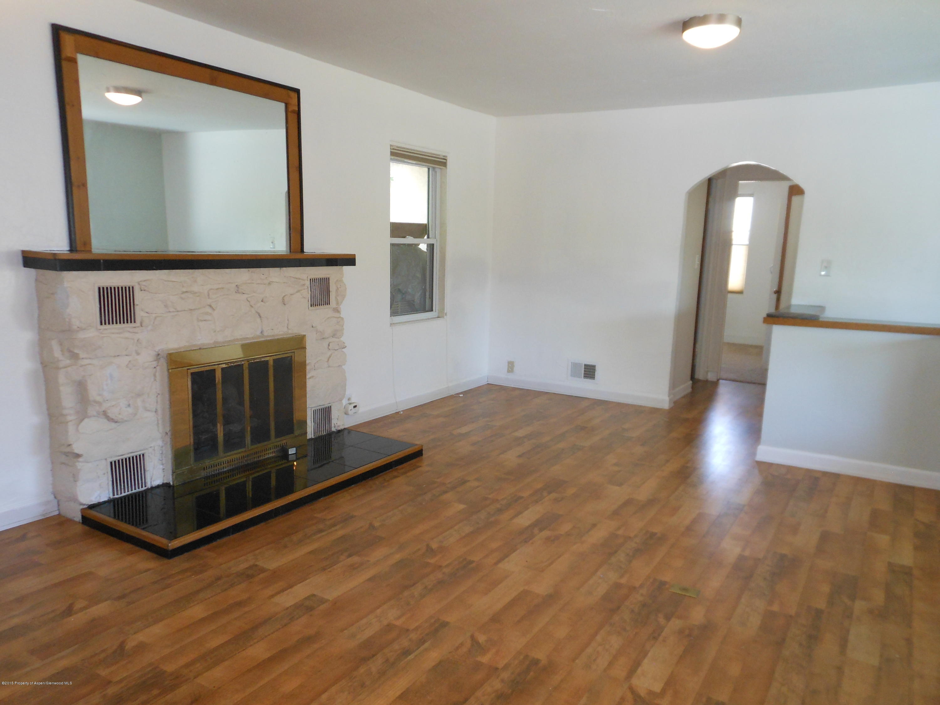 300 East 7th Street Rifle, CO 81650 - Photo 8 of 24 a view of a livingroom with wooden floor and a fireplace