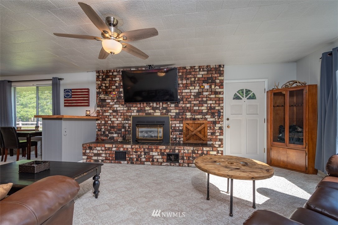 1311 Koontz Road Chehalis, WA 98532 - Photo 9 of 16 a living room with furniture a flat screen tv and a fireplace