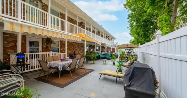 a view of a patio with couches table and chairs and potted plants