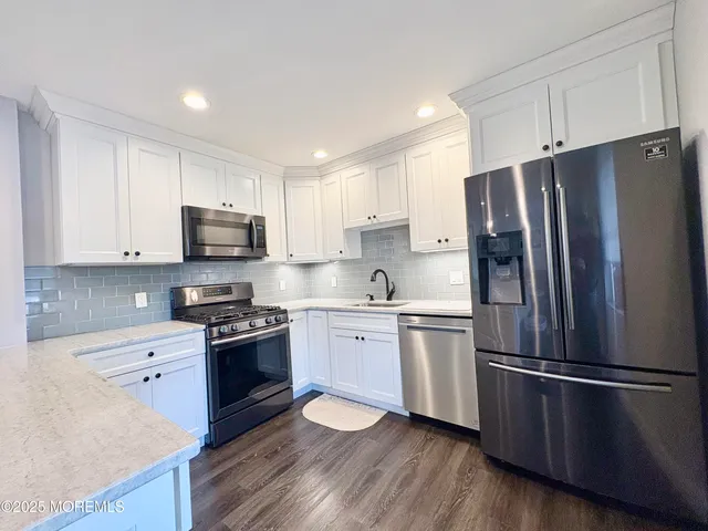 a kitchen with stainless steel appliances a refrigerator stove microwave and sink