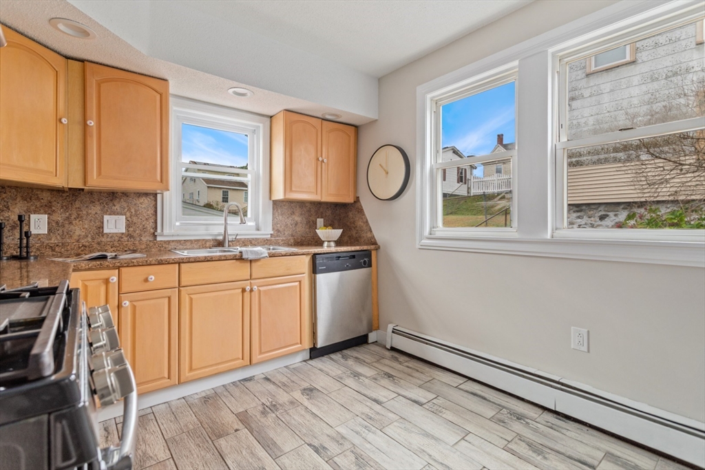 50 Shawmut Street Lawrence, MA 01841 - Photo 12 of 38 a kitchen with granite countertop a stove cabinets and wooden floor