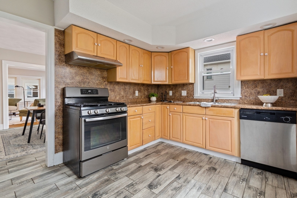 50 Shawmut Street Lawrence, MA 01841 - Photo 13 of 38 a kitchen with stainless steel appliances granite countertop a stove a sink and a microwave