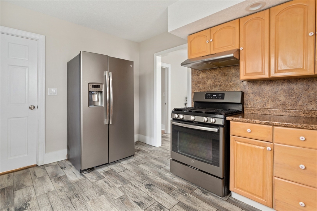 50 Shawmut Street Lawrence, MA 01841 - Photo 14 of 38 a kitchen with stainless steel appliances granite countertop a stove and a refrigerator