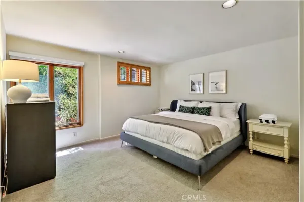 a bedroom with a bed window and two lamp on table