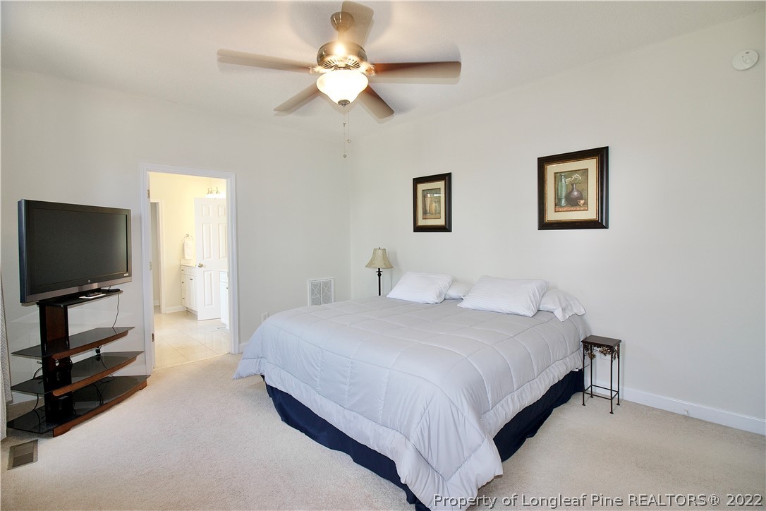 215 Kelly Road Pinehurst, NC 28374 - Photo 12 of 27 a bedroom with a bed and a flat screen tv
