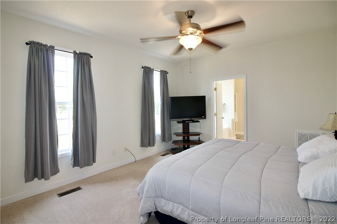 215 Kelly Road Pinehurst, NC 28374 - Photo 13 of 27 a bedroom with a bed and a flat screen tv