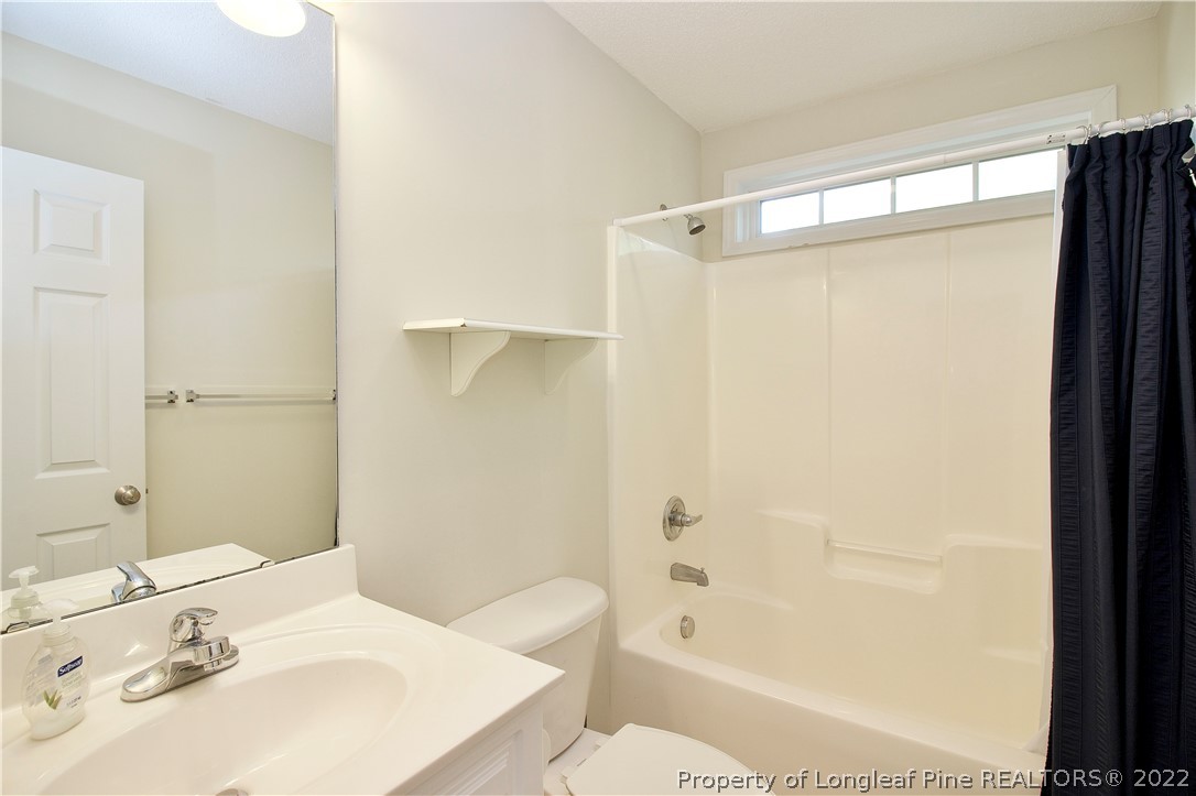 215 Kelly Road Pinehurst, NC 28374 - Photo 19 of 27 a bathroom with a sink a toilet and shower