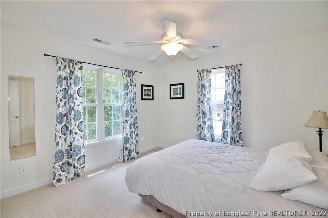 215 Kelly Road Pinehurst, NC 28374 - Photo 20 of 27 a bedroom with a large bed and a chandelier
