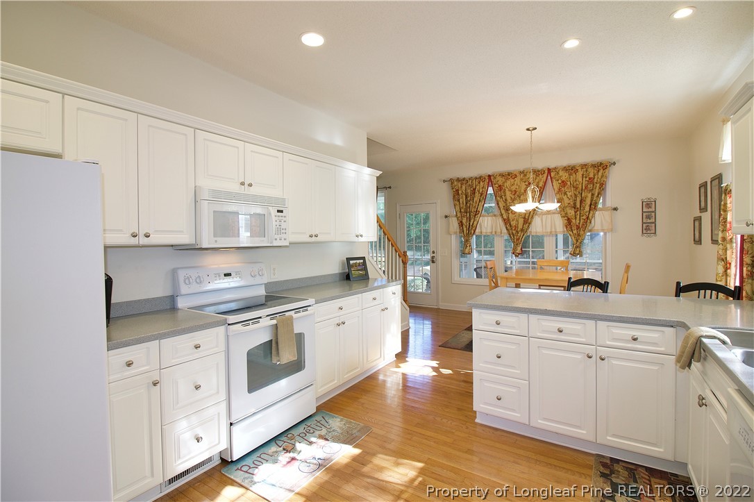 215 Kelly Road Pinehurst, NC 28374 - Photo 5 of 27 a kitchen with white cabinets appliances and sink