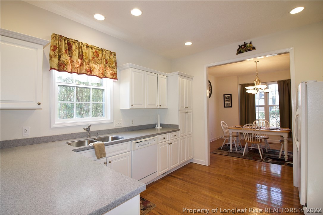 215 Kelly Road Pinehurst, NC 28374 - Photo 6 of 27 a kitchen with sink cabinets and dining table