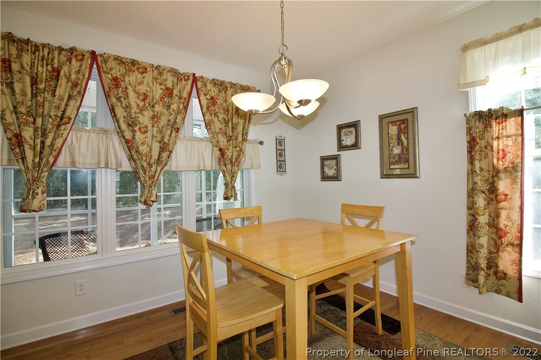 215 Kelly Road Pinehurst, NC 28374 - Photo 8 of 27 a view of a dining room with furniture and wooden floor