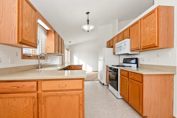 a kitchen with stainless steel appliances granite countertop a sink a stove cabinets and a window