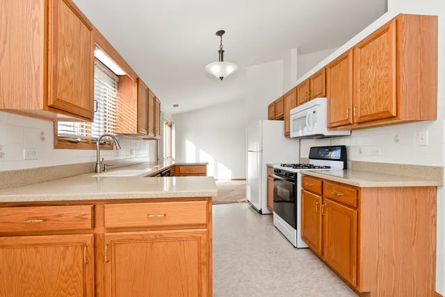 a kitchen with stainless steel appliances granite countertop a sink a stove cabinets and a window