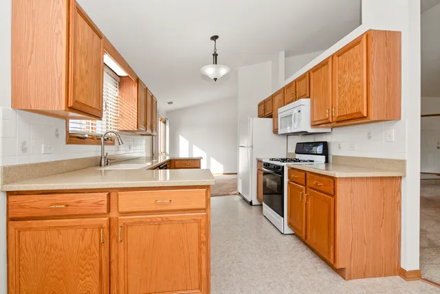 a kitchen with stainless steel appliances granite countertop a sink a stove cabinets and a refrigerator