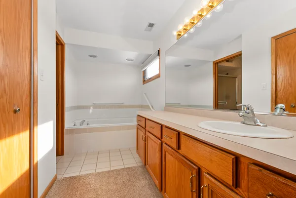 a spacious bathroom with a bathtub sink and mirror
