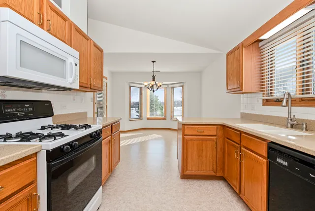 a kitchen with stainless steel appliances granite countertop a stove a sink and a microwave