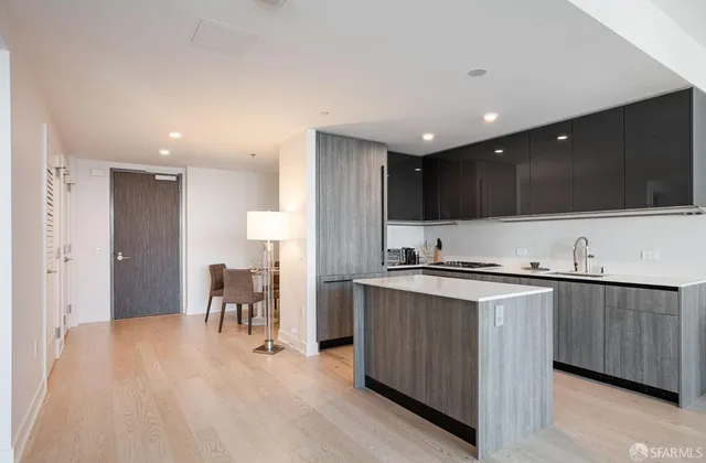 a kitchen with stainless steel appliances a table and chairs