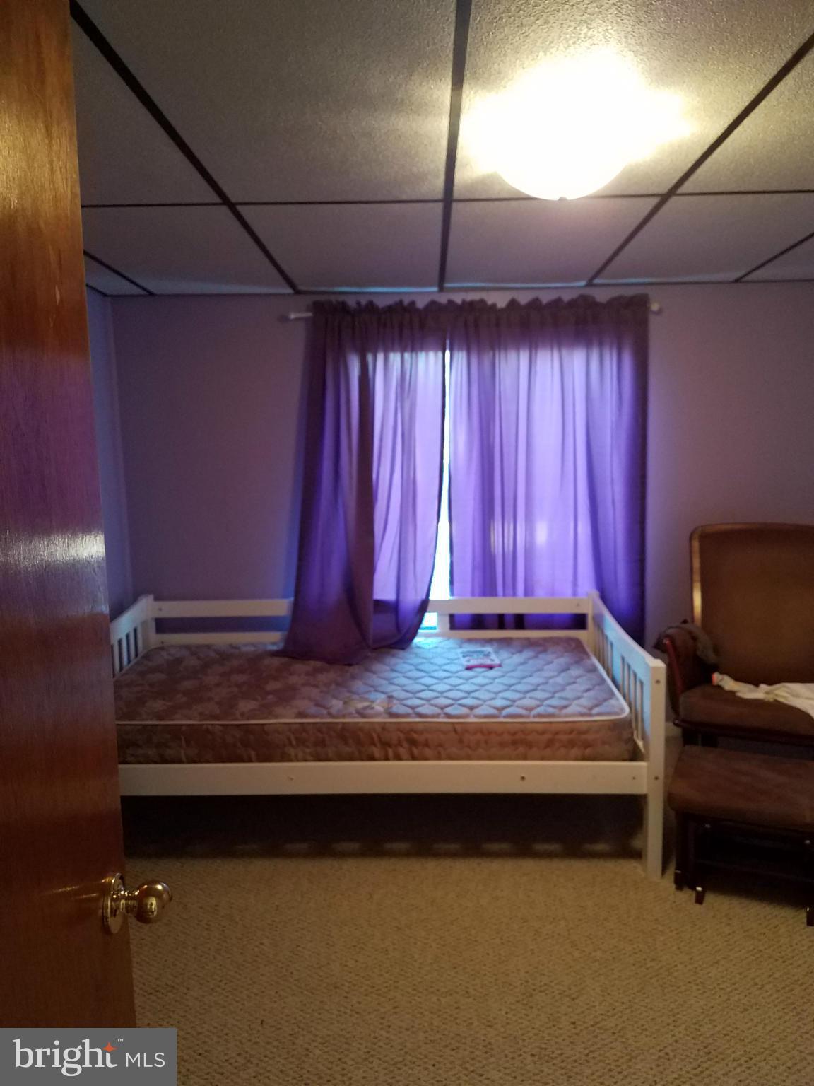 3203 River Drive Road Baltimore, MD 21219 - Photo 12 of 18 a bedroom with bed and a chandelier
