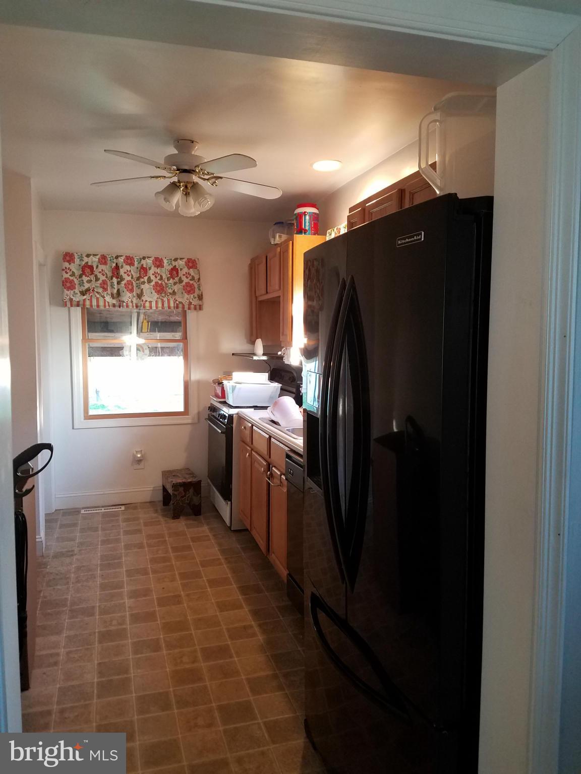 3203 River Drive Road Baltimore, MD 21219 - Photo 5 of 18 a kitchen with a refrigerator a sink and cabinets