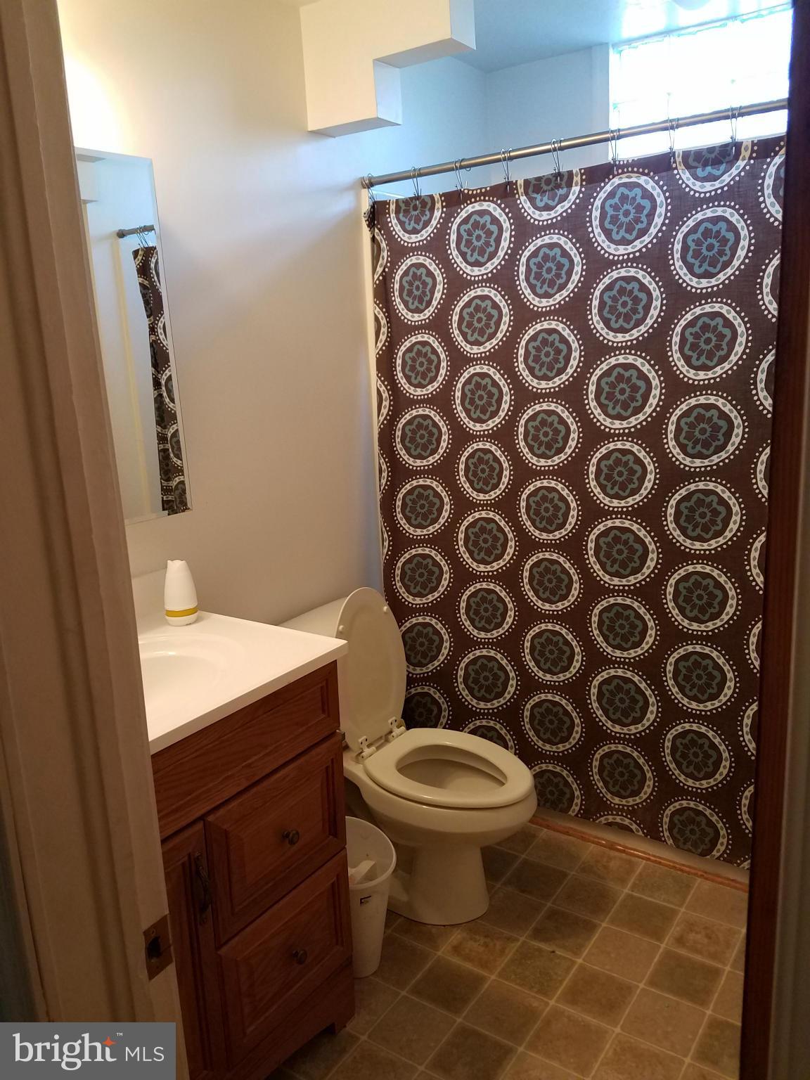 3203 River Drive Road Baltimore, MD 21219 - Photo 6 of 18 a bathroom with a toilet and a shower curtain