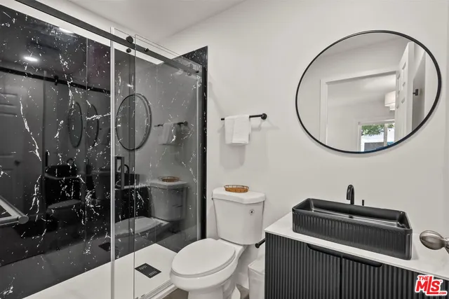 a bathroom with a toilet a sink and shower