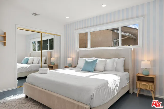 a bedroom with a large bed and a window