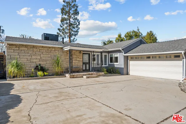 a view of a house with a backyard and garage