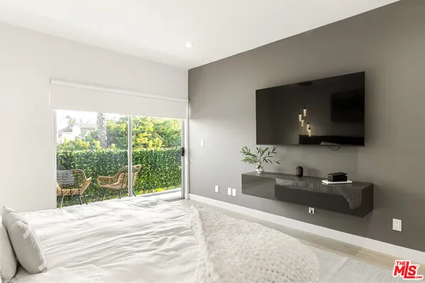 a bedroom with a bed and a flat tv screen