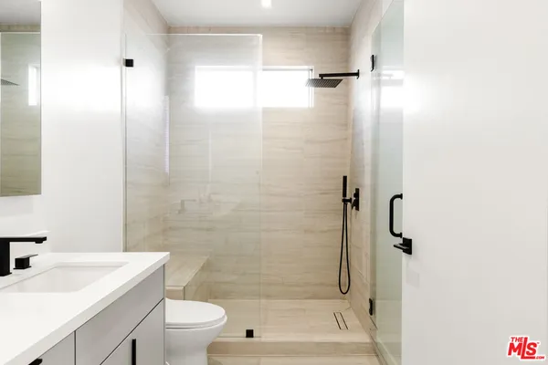 a bathroom with a sink a toilet and shower