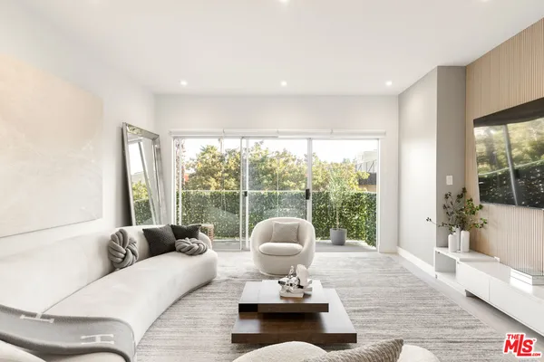 a bedroom with furniture and a large window